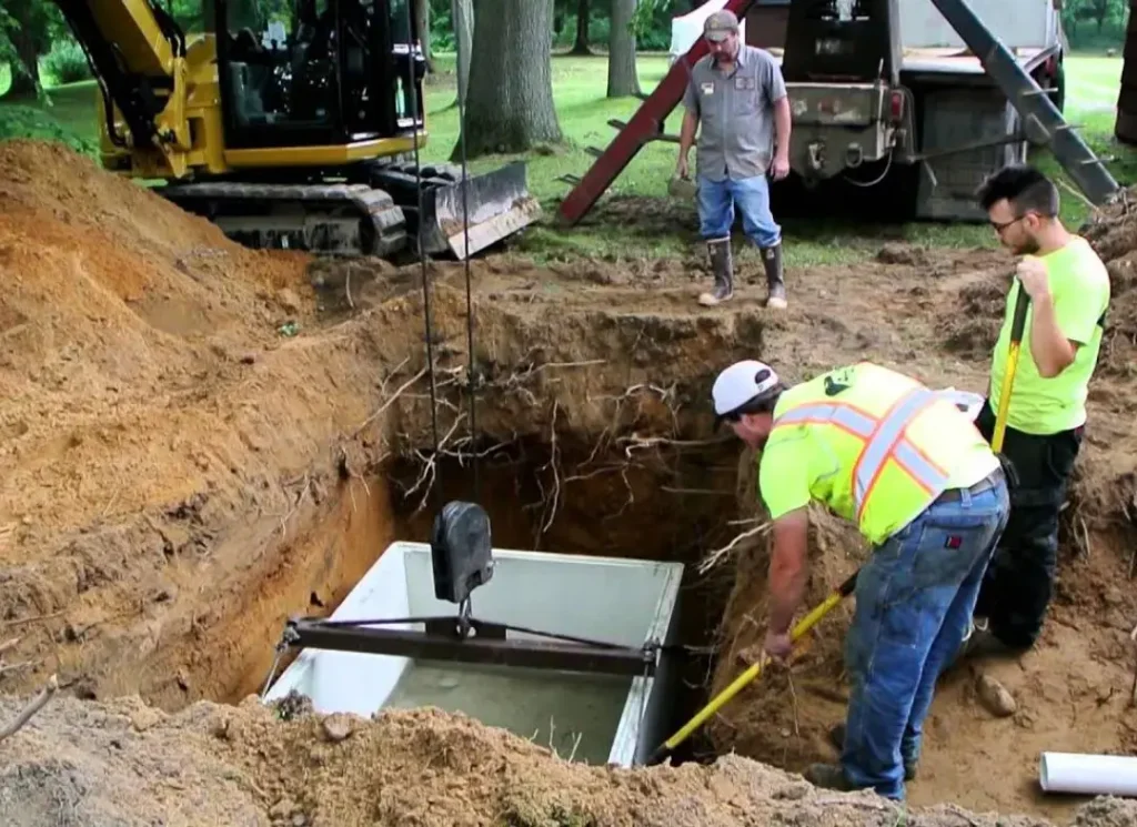 Workers installing septic tank